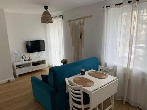 a living room with a blue couch and a table at Przytulna kawalerka nad Jeziorem Długim darmowy parking i rowery in Olsztyn