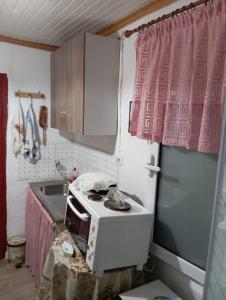 a small kitchen with a microwave and a sink at Irini's house in Panayia