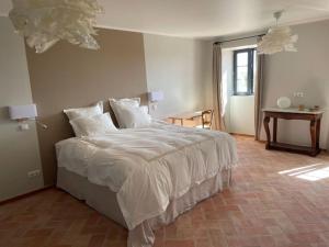 ein Schlafzimmer mit einem großen Bett mit weißer Bettwäsche in der Unterkunft Quinta do Coelhoazul in Quelfes + 37 Fotos