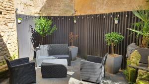 a patio with chairs and potted plants and a fence at Studio du 44 in Poitiers