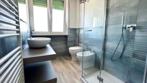 Un baño con inodoro y ducha de cristal. en P022 - Porto Recanati, nuovissimo bilocale fronte mare, en Porto Recanati