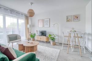 a living room with a green couch and a table at Sweet Green - T2 avec balcon à Toulouse in Castanet-Tolosan