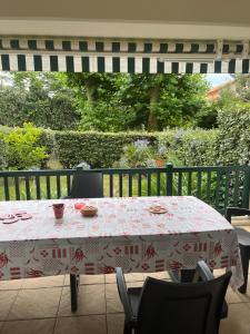 a table with a red and white table cloth on a patio at Appartement in Capbreton