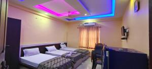 a room with two beds and a purple light at geo gardens residency in Alwaye +16 photos
