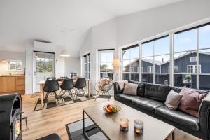 a living room with a couch and a table at Lovely Spa House - 1006 in Hvide Sande