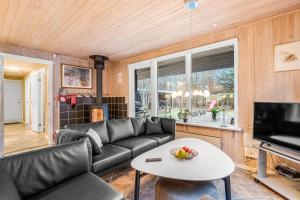 ein Wohnzimmer mit Sofa und Tisch in der Unterkunft Lovely 6-Person Cottage With Outdoor Sauna - 1007 in Ringkøbing