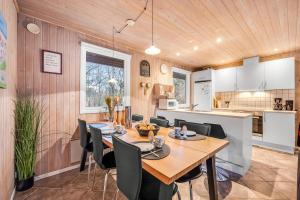 ein Esszimmer und eine Küche mit Tisch und Stühlen in der Unterkunft Lovely 6-Person Cottage With Outdoor Sauna - 1007 in Ringkøbing