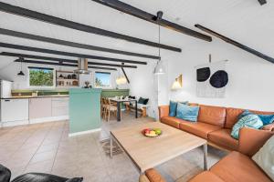 a living room with a couch and a table at Vacation Home Renovated In 2023 With A 6-Person Hot Tub - 1010 in Ringkøbing