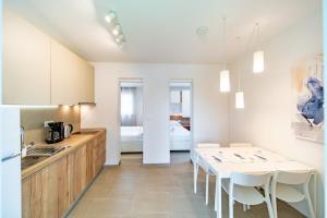 a kitchen with a table and a kitchen with a bed at Arti Holiday Homes in Banjol
