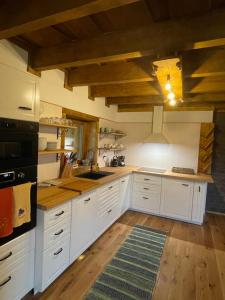ザズリヴァにあるChalet Grúnikの白いキャビネットとウッドフロアの広いキッチン +26枚の写真