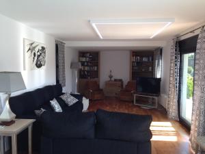 Una sala de estar con un sofá y un televisor. en La Primera Villa, en Sa Torre
