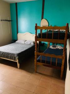 a bedroom with two bunk beds and a green wall at Casa em Peruibe 3 dormitórios sendo 1 suite Pe na Areia in Peruíbe