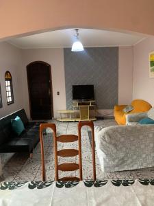 a living room with a bed and a chair at Casa em Peruibe 3 dormitórios sendo 1 suite Pe na Areia in Peruíbe