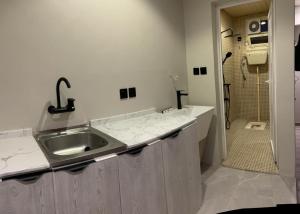 a white bathroom with a sink and a shower at Golden New Al Andalus Abha in Abha