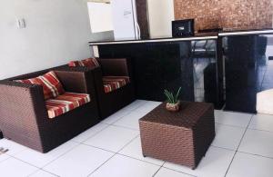 dwa wiklinowe krzesła i stół w pokoju w obiekcie Pousada Brisa do Mar w mieście Aracaju