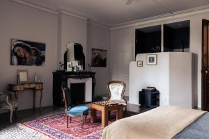 a bedroom with a refrigerator and two chairs and a table at La promesse de l aude in Sallèles-dʼAude