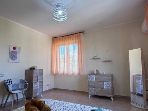 Un dormitorio con una cama y una ventana y una silla. en Casa Lana, en Cabras