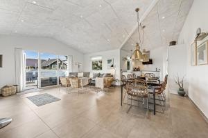 Exclusive Activity House From 2018 - 1022 في رينكوبنج: غرفة طعام وغرفة معيشة مع طاولة وكراسي