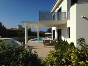 a white house with a balcony and a swimming pool at La Primera Villa in Sa Torre