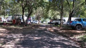 un groupe de voitures garées à côté d'une route avec des arbres dans l'établissement Westvaal Holiday Resort Campsites - Bring your own Tent or Caravan, à Parys
