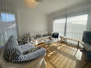 a living room with a couch and a television at Maison familiale - Plage 300m in Jullouville-les-Pins