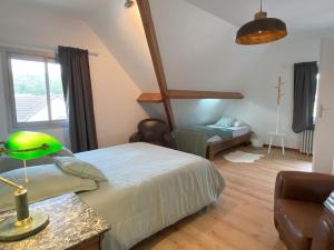 a bedroom with a bed with a green lamp on a table at Maison familiale - Plage 300m in Jullouville-les-Pins