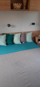 a bed with several pillows on top of it at Mobil home neuf 6 personnes in La Tremblade +2 photos