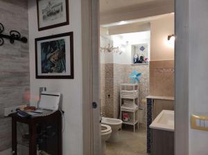 un bagno con un water e un lavandino con un computer portatile di Monolocale Castello Cagliari centro storico a Cagliari Altre 27 foto