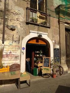 un ingresso di un ristorante con una persona seduta sulla soglia di Monolocale Castello Cagliari centro storico a Cagliari