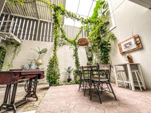 a room with a table and chairs and plants at Royal Residence 3BR Exclusive Town House in West Surabaya by Le Ciel Hospitality in Surabaya