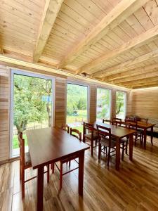 une salle à manger avec tables, chaises et fenêtres dans l'établissement Lazer Çardaku Guest House, à Valbonë 27 autres photos