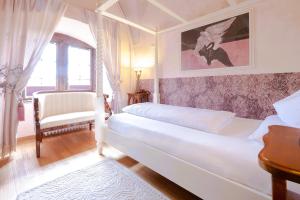 a bedroom with a bed and a chair and a window at Hotel & Tagungszentrum Schloss Hohenfels in Hohenfels
