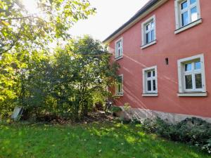 a red house with a tree in front of it at Ferienwohnung Pale in Bechhofen