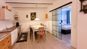 a kitchen with a table and chairs and a bedroom at Ferienwohnung Pale in Bechhofen