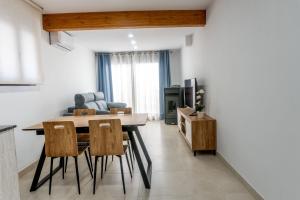 a kitchen and living room with a table and chairs at Les Gubies in Beceite