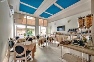 a dining room with tables and chairs and blue ceilings at Hotel London in Viareggio