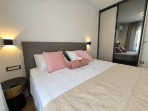 ein Schlafzimmer mit einem großen Bett mit rosa und weißen Kissen in der Unterkunft Luxury Apartments Marina View in Vodice