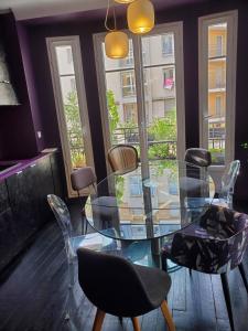a dining room with a glass table and chairs at Bel appartement à Clichy sur Seine in Clichy