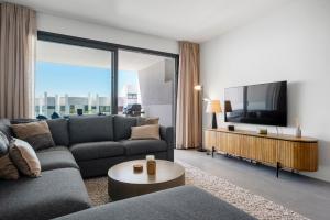 ein Wohnzimmer mit Sofa und Fernseher in der Unterkunft Luxury Seaview Resort Apartment in Manilva