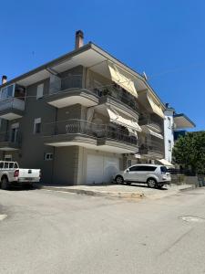 a large apartment building with cars parked in front of it at La kaza studio in Ofrínion