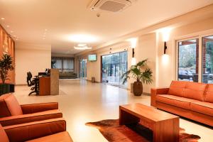 Un vestíbulo de oficina con muebles naranjas y una mesa. en Fantástico Flat no Serra Class em Canela-RS, en Canela