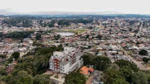 una vista aérea de una ciudad con un edificio blanco en Fantástico Flat no Serra Class em Canela-RS, en Canela