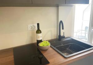a bottle of wine and a bowl of grapes on a kitchen counter at Campana 2 in Argostoli