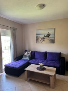 a living room with a purple couch and a coffee table at Sunrise house apartments in Ulcinj