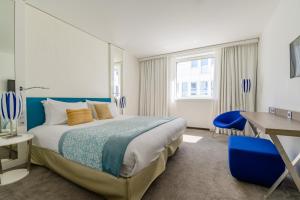 a hotel room with a bed and a desk at Golden Tulip Marseille Euromed in Marseille