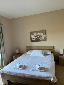 a bedroom with a bed with towels on it at Sunrise house apartments in Ulcinj