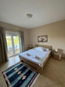 a bedroom with a bed and a large window at Sunrise house apartments in Ulcinj