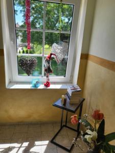 a window with a toy bird sitting on a window sill at Gemütliches Ferienhaus - PENTER in Habrachćicy