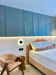 a bedroom with a bed and a chair at Tramonto Maisonettes & Suites in Parga