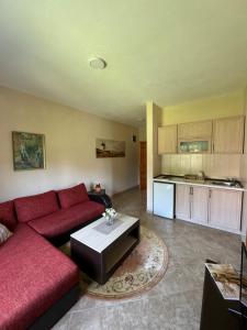 a living room with a red couch and a kitchen at Sunrise house apartments in Ulcinj
